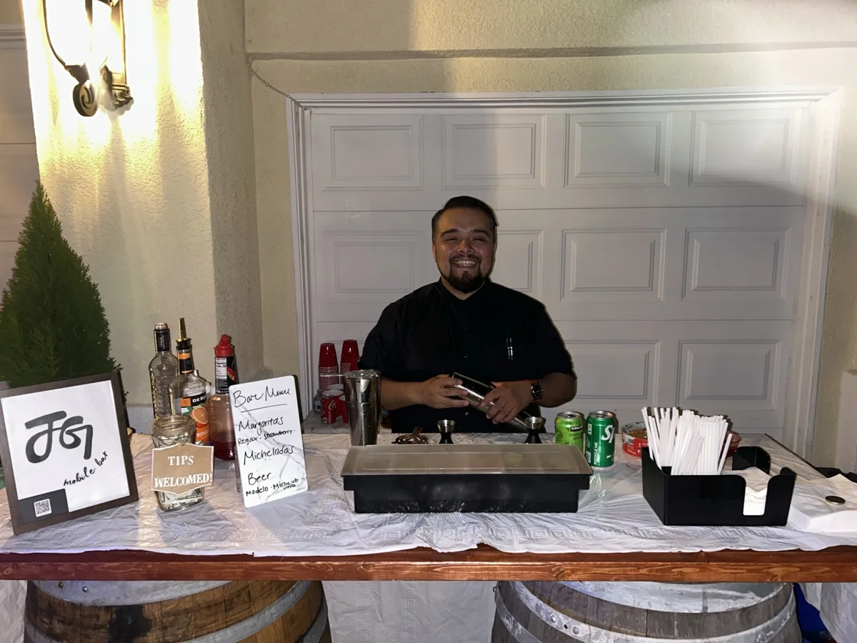 Johnny smiling behind the bar at his first private event